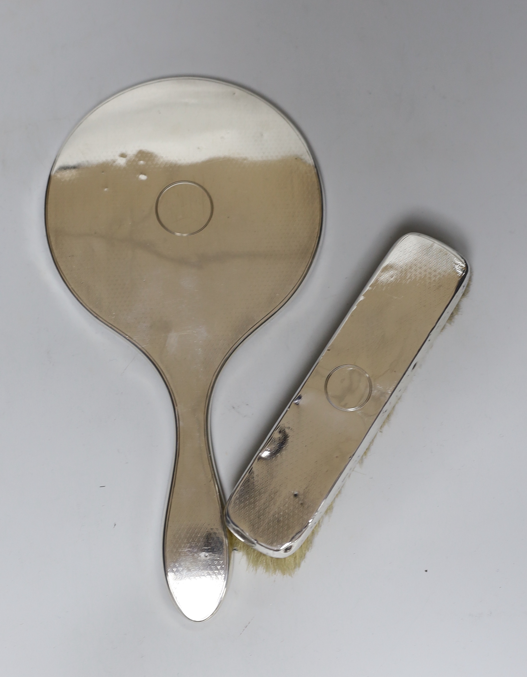 A George V silver mounted glass manicure stand with six accessories, height 12.5cm, a similar silver mounted hand mirror and brush.